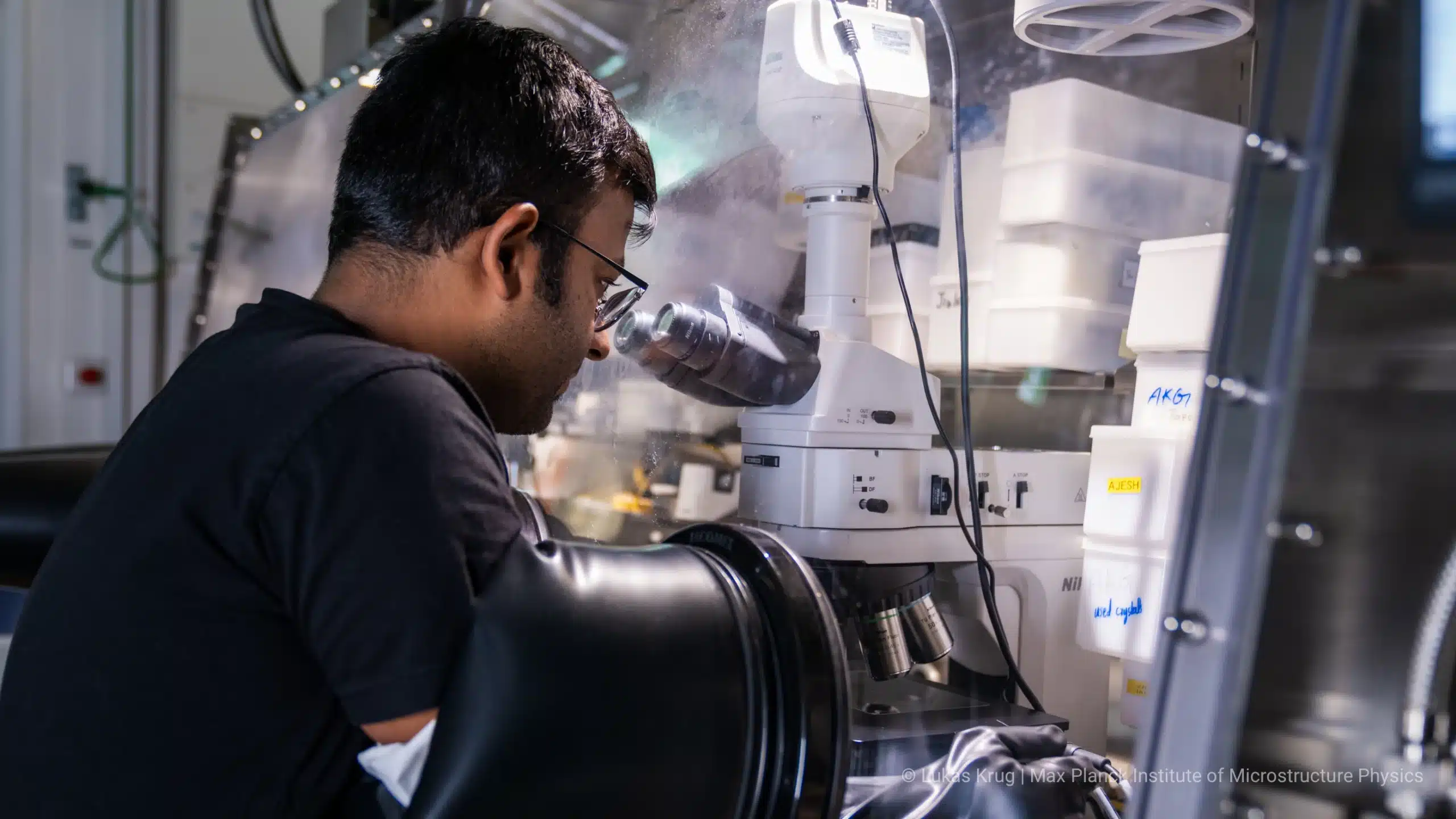 Anirban Chakraborty working with a 2D-material glovebox microscope at MPI of Microstructure Physics