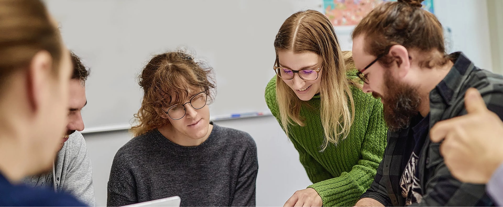 Graduate researchers working together on a project during a group discussion.